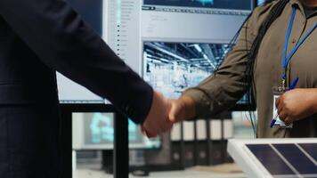 Investors shaking hands, closing deal after reviewing solar technology reports. Shareholders doing handshake, meeting to discuss investment opportunities in eco friendly energy production, camera B video