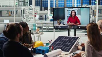 Factory engineers doing online videocall to refine designs for increased energy output using data. Photovoltaics plant specialists design solar cell prototypes in teleconference meeting, camera A video
