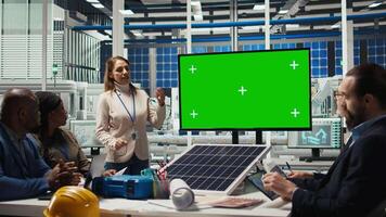 Factory engineers look over assembly lines schematics during business meeting in front of green screen monitor. Experts work on industrial plant configurations using mockup display, camera A video