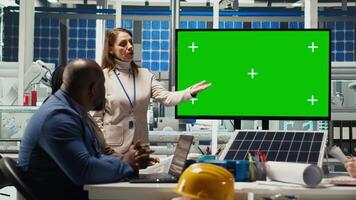 Factory engineers look over assembly lines schematics during business meeting in front of green screen monitor. Experts work on industrial plant configurations using mockup display, camera B video