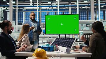 chefer i kontor granskning sol- teknologi rapporter på grön skärm övervaka. aktieägare använder sig av attrapp visa, diskuterar investering möjligheter i grön energi produktion, kamera en video