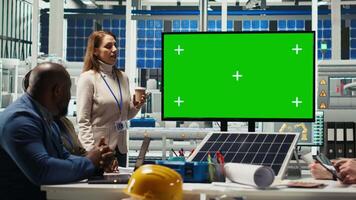 Photovoltaics plant researchers doing meeting, looking at chroma key monitor, evaluating energy production. Experts optimize factory gear energy output, looking at isolated screen display, camera B video
