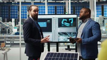 Industrial plant engineers discussing ways to refine designs for increased energy output. Factory employees in workspace collaborating on solar cell prototypes on chroma key notebook, camera A video