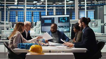 Factory manager presents business models to investors, highlighting innovative strategies for expanding production. Shareholders discuss integrating automation technology in industrial plant, camera A video