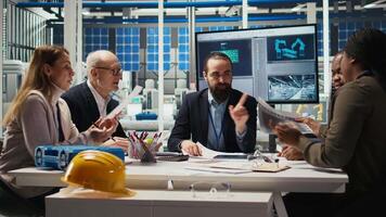 Engineers study detailed schematics of solar panel assembly lines, refining production layouts and component configurations for efficiency, outlining documentation for new prototypes, camera A video