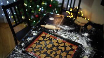 Baking sheet with raw Christmas cookies stands on a table in the room video