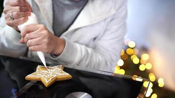 Confectioner draws icing patterns with pastry bag on Christmas cookies video