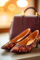 Close-up of dark cherry open-toe shoes with golden accents alongside a stylish handbag in soft lighting photo