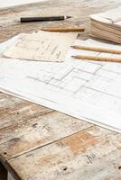 A drafting table showcases an architectural blueprint surrounded by design tools and crumpled sketches photo