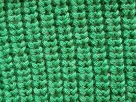 Close-up of textured green fabric, showcasing a fine knit pattern. Ideal for textile and fashion-related content. photo