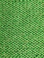 Detailed view of green knitted fabric, displaying a unique stitch. Suitable for fashion, home decor, and crafting projects. photo