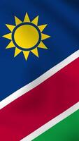 Vertical, portrait waving national flag of Namibia. Smooth animation with highly detailed, realistic animated background for social media, screens smartphone. Cloth motion, official colors. video