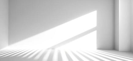 Bright, white room with natural sunlight. Linear shadows dance across floor and empty wall with copy space, creating play of contrasts and geometry, serenity and calmness, purity and photo