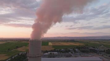 aerial view of steaming pipe of soviet concrete factory at sunset. video