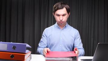 Office worker looking stressed at paperwork and holding a folder with documents video