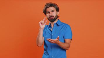 Man showing a little bit gesture with sceptic smile showing minimum sign measuring small size video