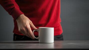 Person in Red Shirt Reaching for a White Mug on Gray Surface photo