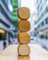 Four Stacked Light Brown Wooden Blocks Against Blurred City Background photo