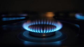 Blue flames on a gas stove burner in the dark photo