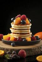 A stack of pancakes topped with berries and oranges photo