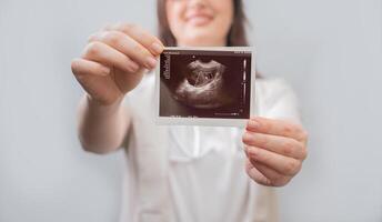 Obstetrician explains ultrasound results to patient, offering optimal methods for conception and vitamin therapy. photo