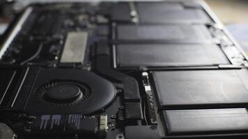a close up of a MacBook motherboard with a fan photo