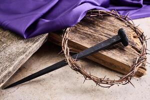 Easter background depicting the crucifixion with a rustic wooden cross, crown of thorns and nails. photo
