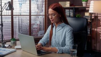 Concentrated Caucasian woman business lady businesswoman girl female in office working laptop computer thinking idea solution think typing net internet consulting online job at table profession work video