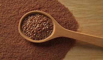 Wooden spoon overflowing with nutritious flax seeds on vibrant red sand photo