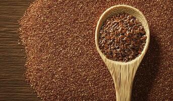 Wooden spoon overflowing with nutritious flax seeds on vibrant red sand, highlighting culinary uses and health benefits photo