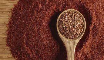 Wooden spoon overflowing with nutritious flax seeds photo