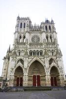 Amiens Cathedral front view with Gothic details and red doors photo