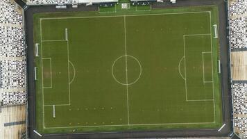 Top-Down Aerial View of Football Field with Marked Lines and Empty Stands photo