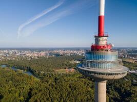 Close-up view of a telecommunications tower with an observation deck. Modern architecture and panoramic cityscape in the background photo