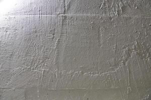 The texture of a white stone wall. Uneven surface, grainy structure with space for copying photo