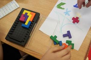 A plastic tetris game. Leisure time for children on vacation. An unrecognizable child is playing a plastic-based puzzle game. With space to copy photo