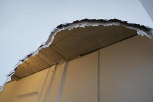 Broken drywall, a background crack with a white wall texture. With space to copy photo