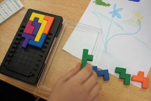 Leisure time for children on vacation. With space to copy. An unrecognizable child is playing a plastic-based puzzle game. photo