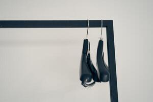 A row of two plastic metal-based clothes hangers. With space to copy photo