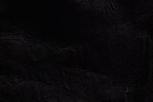 The texture of the black stone surface. Rough uneven wall with scratches with space to copy photo