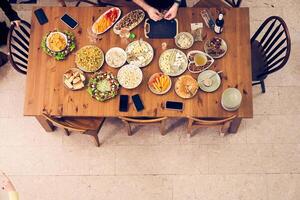 High-angle view of a festive dining table with snacks, vegetables and fruits. A man prepares a table for the holiday. With space to copy photo