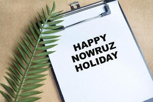 Concept of Happy Nowruz Holiday write on paperwork isolated on Wooden Table. photo