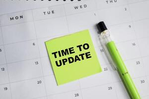 Concept of Time to Update write on sticky notes and calendar isolated on Wooden Table. photo