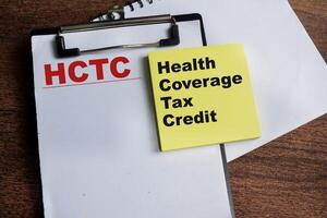 Concept of HCTC - Health Coverage Tas Credit write on sticky notes isolated on Wooden Table. photo