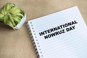 Concept of International Nowruz day write on book isolated on Wooden Table. photo