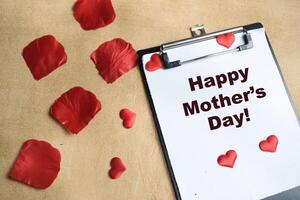Concept of Happy Mother's Day write on paperwork isolated on Wooden Table. photo