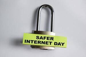 Concept of Safer Internet day write on sticky notes and padlock isolated on Wooden Table. photo