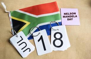 Celebrating Nelson Mandela Day 18 July and african flag on the table photo