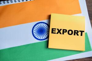 Concept of Export write on sticky notes and india flag isolated on Wooden Table. photo