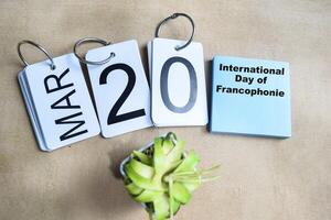 March 20. International Day of Francophonie with Calendar on table background photo